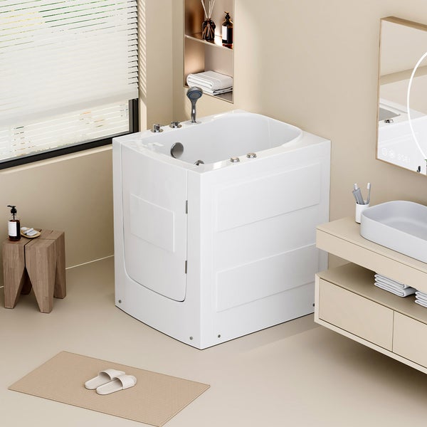 Sitzbadewanne mit Tür für barrierefreies Baden in einem hellen, modernen Badezimmer mit Waschtisch, Spiegel und Holzschemel.