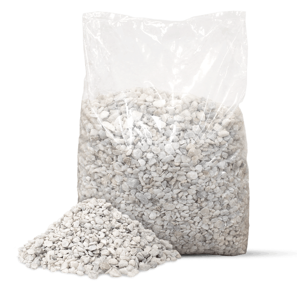 Transparenter Sack mit hellem Zierkies und ein kleiner Haufen feiner Kieselsteine davor.