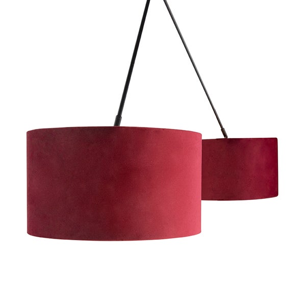 Zweiflammige Pendelleuchte mit bordeauxroten Samtschirmen in zwei verschiedenen Größen an schwarzen Metallstäben.