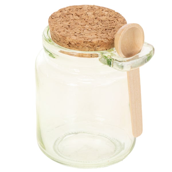 Vorratsglas aus Klarglas mit Korkdeckel und passendem Holzlöffel in einer seitlichen Halterung.