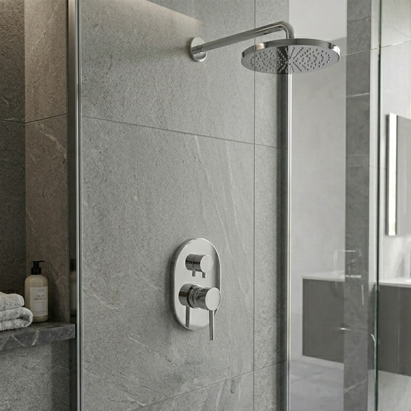 Moderne Dusche mit runder Regenbrause und ovaler Unterputz-Armatur in einem Bad mit grauen Steinoptik-Fliesen und gläserner Trennwand.