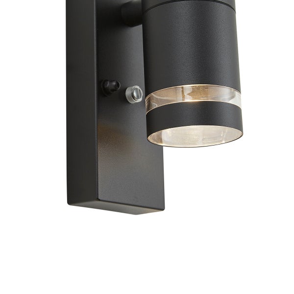 Moderne Außenwandleuchte in Schwarz mit Bewegungssensor und zylindrischem Strahler.