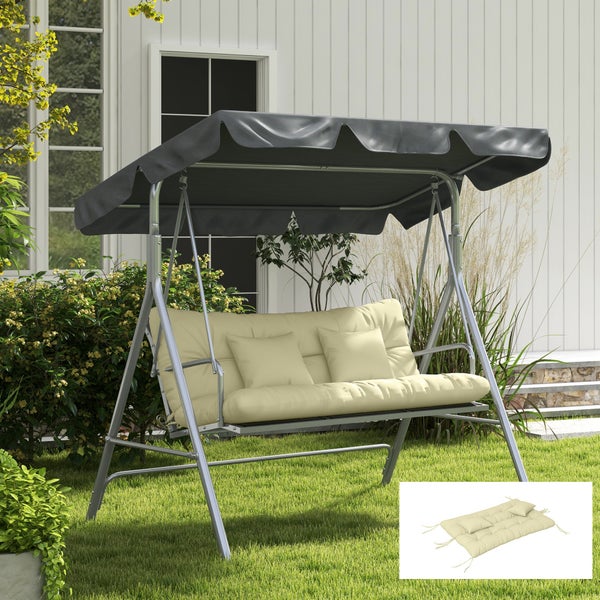 Eine Hollywoodschaukel aus Metall mit Dach und Polsterauflage im Garten vor einem Haus mit weißen Fassadenelementen.
