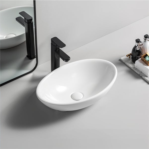 Ovales weißes Aufsatzwaschbecken aus Keramik mit schwarzer Armatur in einem modernen Badezimmer.