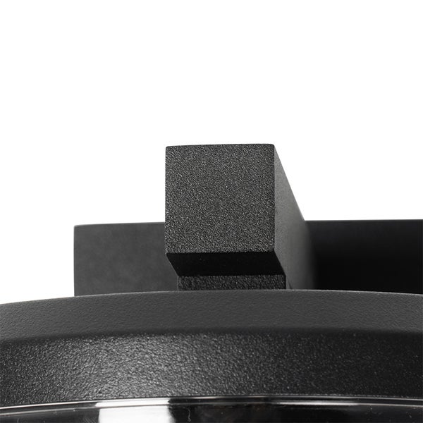 Nahaufnahme einer schwarzen Wandleuchte aus strukturiertem Metall.