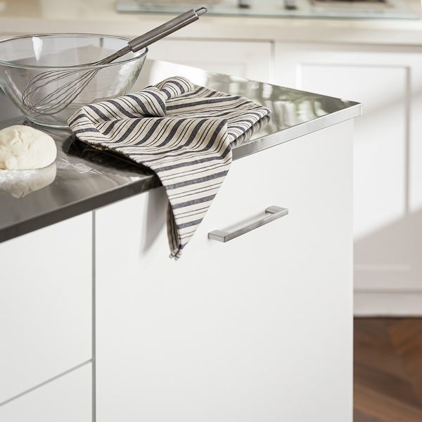 Küchenszene mit Rührschüssel, Schneebesen, Geschirrtuch und Teig auf einer Küchentheke