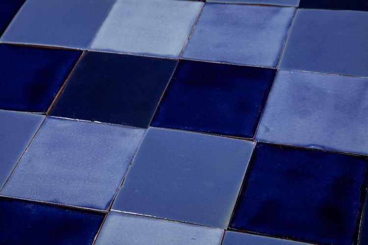 Quadratische Fliesen in verschiedenen Blautönen.