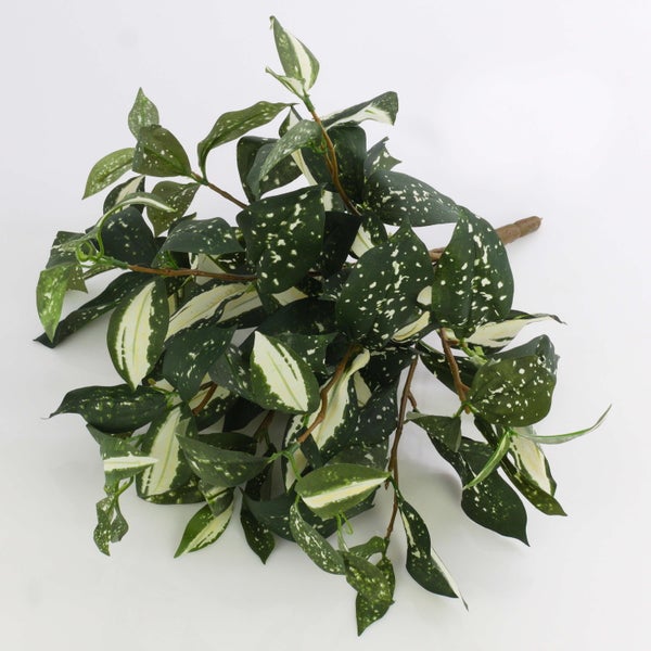 Künstlicher Zweig mit grün-weiß gemusterten Blättern.