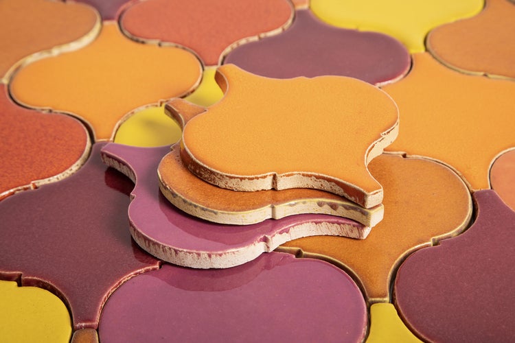 Marokkanische Fliesen in verschiedenen Farben und einem Blumenstrauß auf einem Holztisch