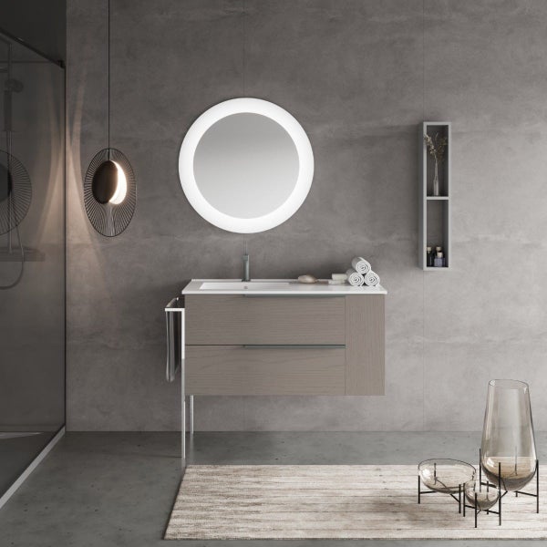 Modernes Badezimmer mit Waschtischunterschrank aus Holz, rundem LED Wandspiegel, Waschbecken und offener Wandablage vor einer grauen Betonwand.