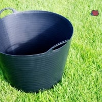 Schwarzer Mörtelkübel auf Rasen