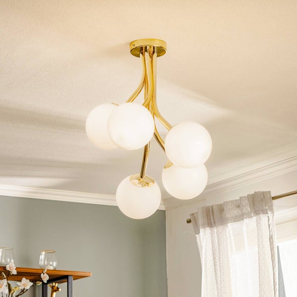 Deckenleuchte mit fünf kugelförmigen Lampenschirmen und goldenem Gestell.