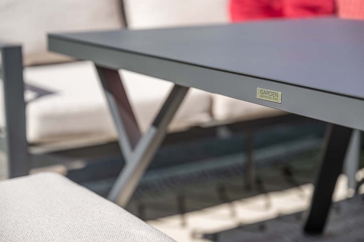 Nahaufnahme der Kante eines Gartentisches mit Garden Impressions Logo.