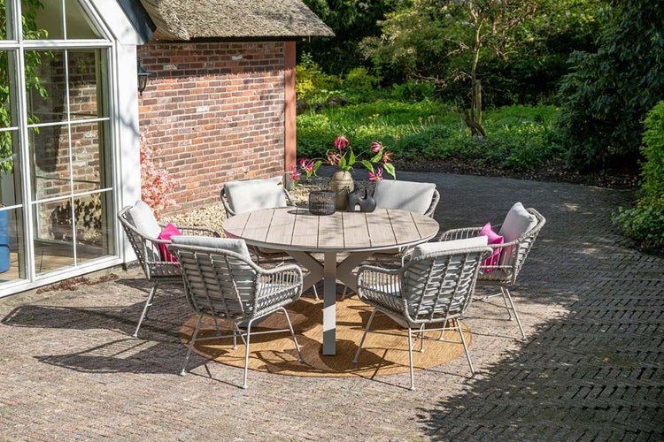 Garten-Essgruppe mit rundem Tisch in Holzoptik und fünf grauen Seilgeflecht-Stühlen auf einer gepflasterten Terrasse im Garten.