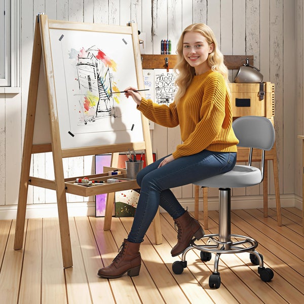 Künstlerin malt ein abstraktes Stadtbild auf einer Staffelei in einem hellen Raum