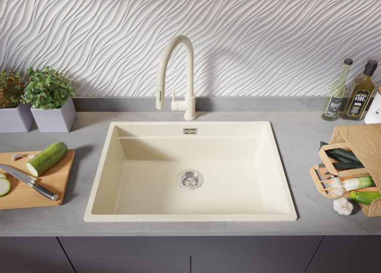 Spüle mit Armatur auf einer Küchentheke mit Lebensmitteln und Küchenutensilien