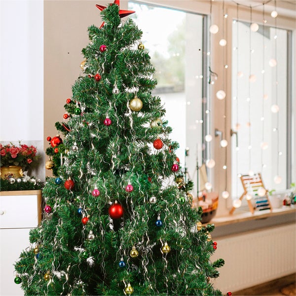 Geschmückter Weihnachtsbaum mit Christbaumkugeln und Christbaumschmuck im Zimmer