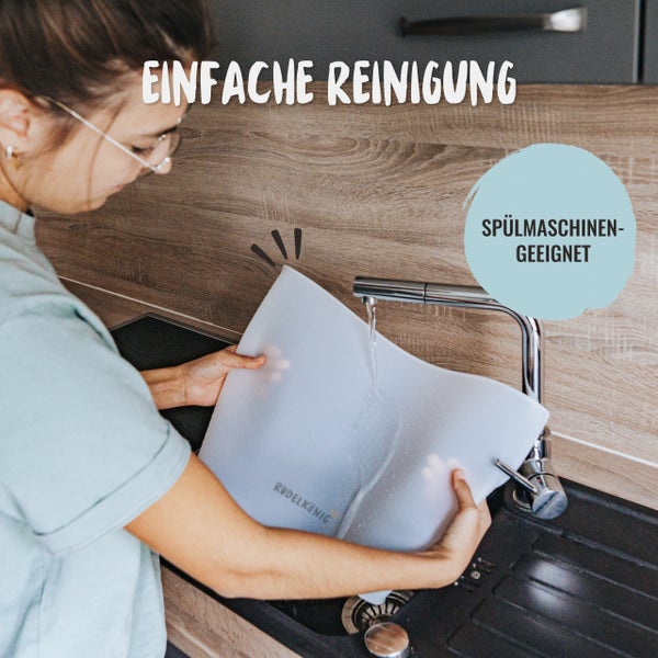 Eine Frau reinigt eine Ruedelkönig Matte unter einem Wasserhahn in einer Spüle. Die Matte ist spülmaschinengeeignet.