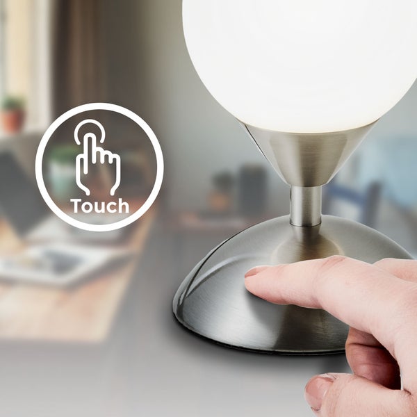 Nahaufnahme einer Tischleuchte mit Touchfunktion und einer Hand, die sie bedient.