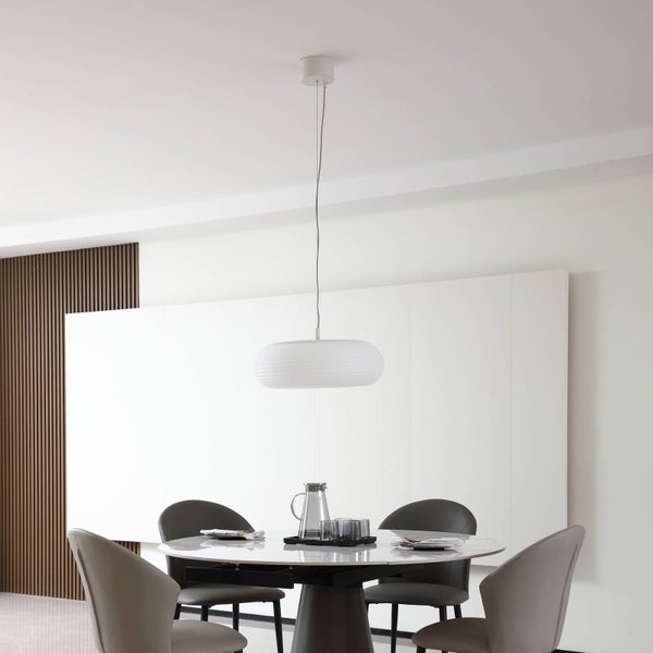 Modernes Esszimmer mit weißer ovaler Pendelleuchte über rundem Tisch und vier Stühlen. Helles, organisiertes minimalistisches Design.