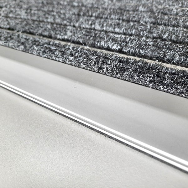 Fußmatte mit Aluminiumprofil und grauen Nadelfilz-Einlagen in Rips-Optik.