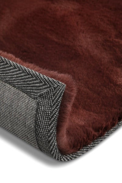 Weinroter Langflor-Teppich, Detailansicht der Ecke mit rutschfestem Rücken und Fischgrat-Einfassung.