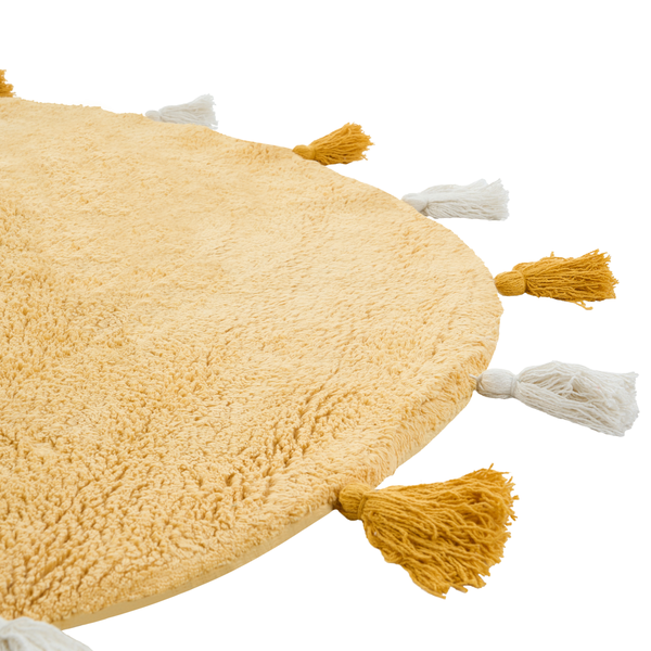 Runder Teppich mit flauschiger Oberfläche und dekorativen Quasten am Rand