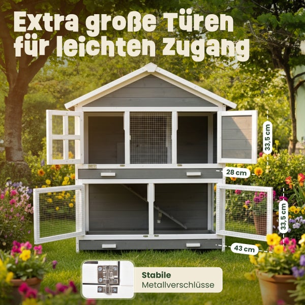 Grau-weißer Kleintierstall aus Holz mit zwei Etagen und vier geöffneten Türen in einem Garten. Türgrößen in Zentimetern und Metallverschluss gezeigt.