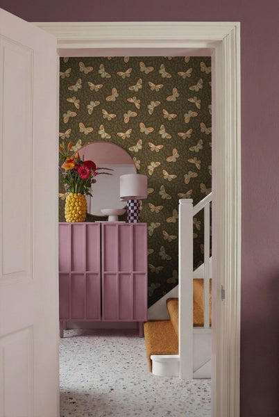 Innenaufnahme eines Flurs mit Tapete, Kommode, Spiegel und Treppe