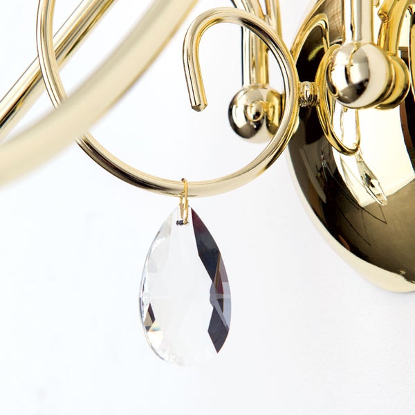 Wandleuchte im klassischen Stil mit glänzender Metalloberfläche und einem hängenden Kristallbehang in Tropfenform.