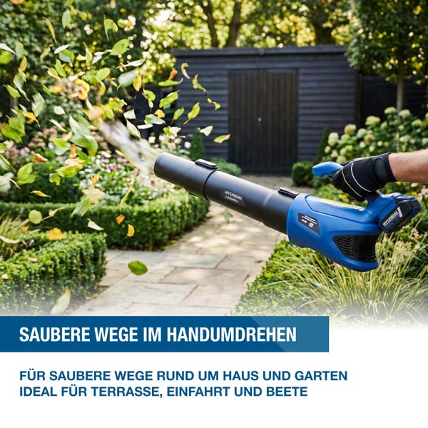 Ein akkubetriebener Laubbläser von Hyundai bei der Gartenarbeit zum Entfernen von Laub auf einem Gartenweg.