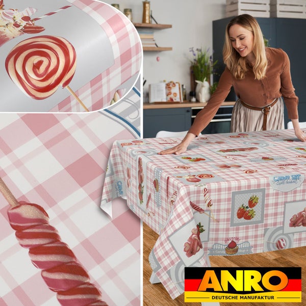Abwaschbare Tischdecke mit rosa-weißem Karomuster und Süßigkeiten-Motiven wie Lollipops auf einem Küchentisch. ANRO Deutsche Manufaktur Logo.