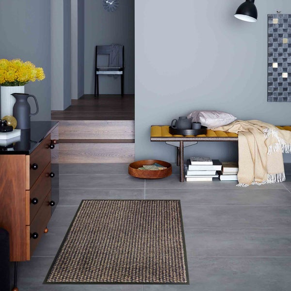 Szene mit einer Fußmatte im Eingangsbereich eines Hauses, mit Möbeln und Dekorationen.