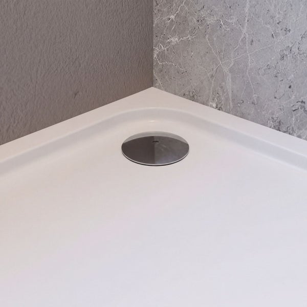Detailansicht einer Duschwanne mit rundem Ablaufdeckel in einer Ecke.
