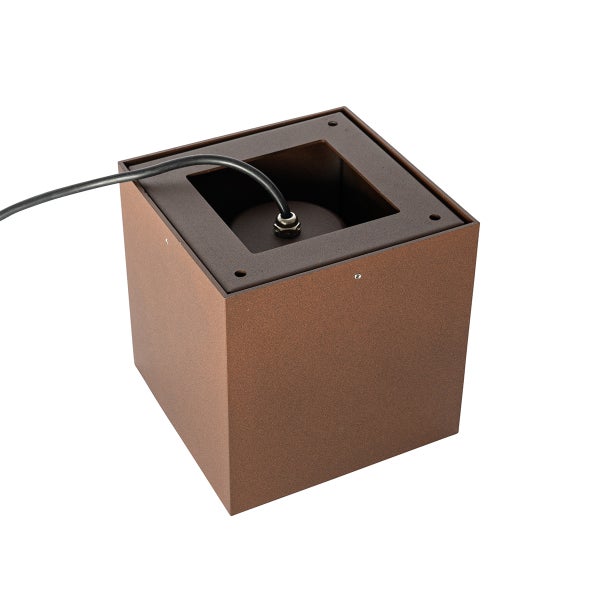 Würfelförmiger Sockel einer Außenleuchte aus Metall in Rostoptik mit einem schwarzen Kabelanschluss.