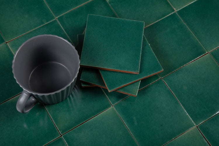 Grüne quadratische Fliesen mit einer Tasse