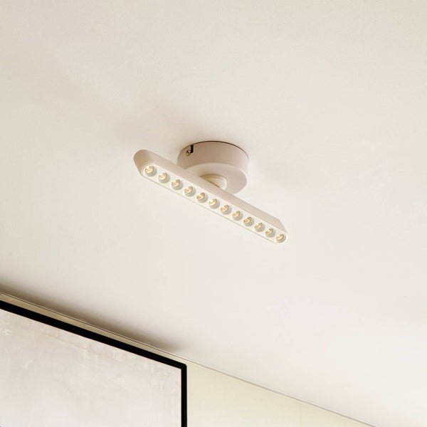 Moderne weiße LED-Deckenleuchte mit schmaler Lichtleiste und mehreren integrierten Lichtpunkten.