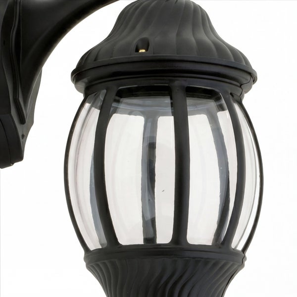 Schwarze Außenwandleuchte mit klarem Glas und dekorativem Metallkäfig.