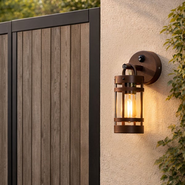 Außenwandleuchte im industriellen Design mit Bewegungsmelder, Metallkäfig und Glaseinsatz.