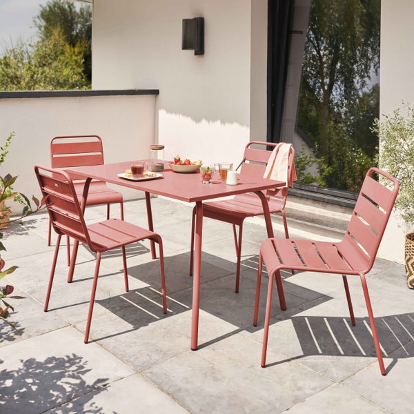 Moderne Garten-Sitzgruppe aus Metall mit einem rechteckigen Tisch und vier Stapelstühlen auf einer hellen Fliesenterrasse.