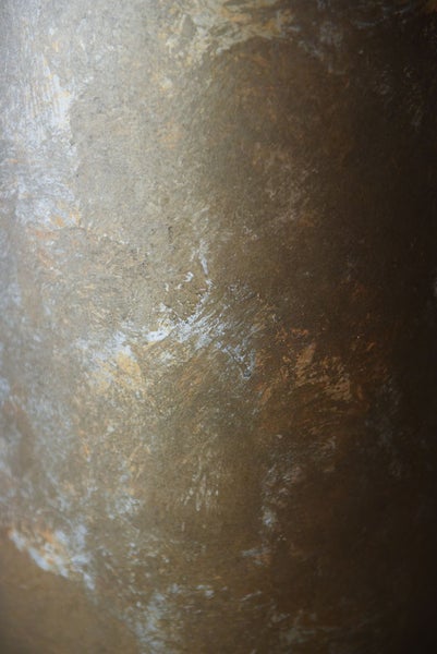 Nahaufnahme einer strukturierten Wandtapete mit Steineffekt und metallischem Glanz.