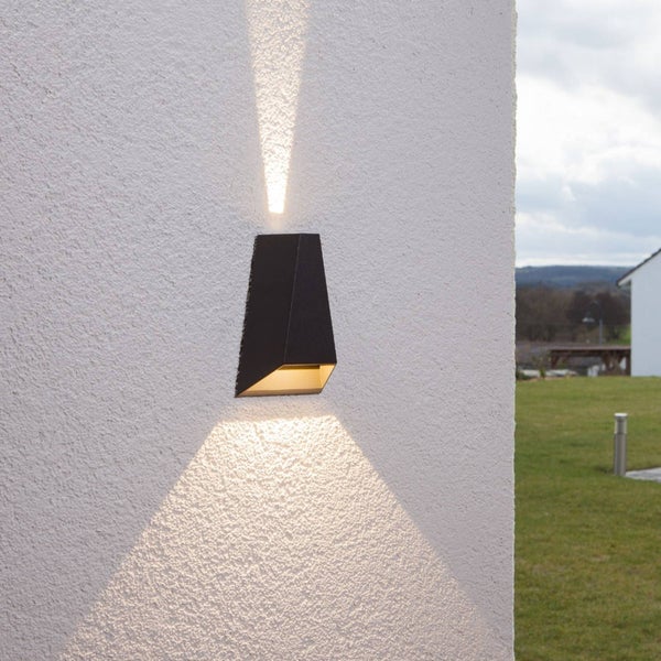 Moderne schwarze Außenwandleuchte mit Lichtkegel nach oben und unten an einer Hauswand.
