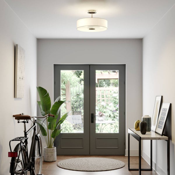 Moderne Deckenleuchte mit weißem, zylindrischem Textilschirm und Metallhalterung in Nickel-Optik.