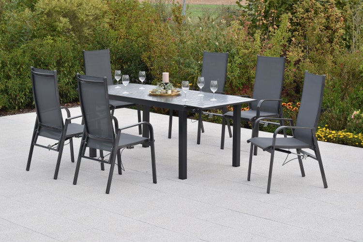 Gartenmöbel-Set bestehend aus einem rechteckigen Esstisch und sechs Hochlehner-Stühlen aus Aluminium und Textilgewebe auf einer Terrasse.