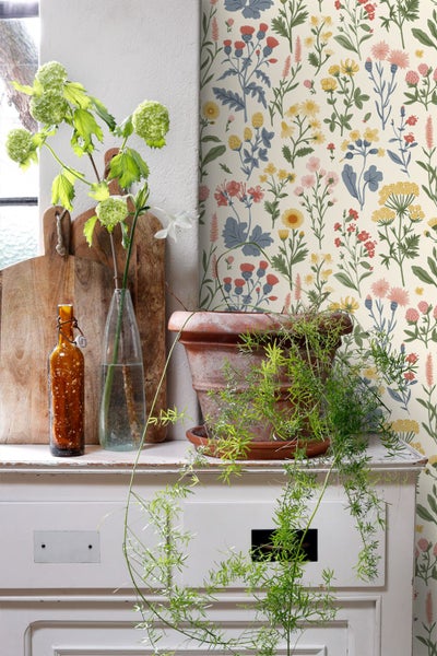 Blumenmuster mit verschiedenen Wildblumen und Kräutern wie Kamille und Disteln im illustrativen Stil.