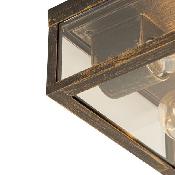 Nahaufnahme einer Deckenleuchte im Industriedesign mit antikem Metallrahmen und klaren Glaspaneelen.