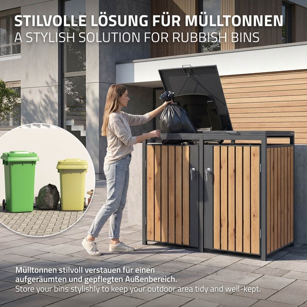 Eine Frau füllt einen Müllbeutel in eine zweifache Mülltonnenbox aus Metall und Holzlamellen in einem aufgeräumten Außenbereich.
