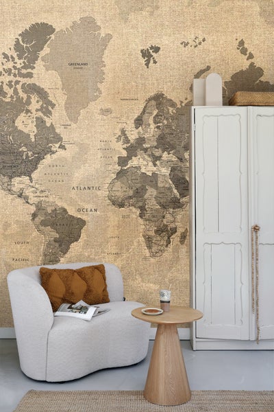 Wohnraum mit Weltkarten-Tapete, Sessel und Holztisch
