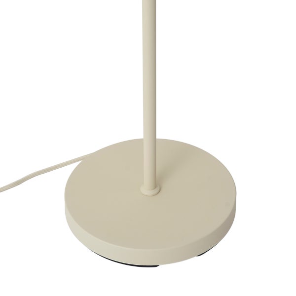 Beiger runder Standfuß einer Stehlampe aus Metall mit Stromkabel