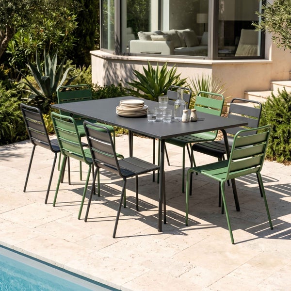 Moderne Gartensitzgruppe mit einem rechteckigen Metalltisch und acht Lattenstühlen auf einer Steinterrasse im Außenbereich.